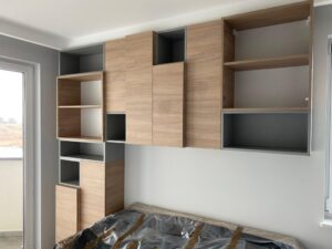 Zabudowa nad łóżkiem — drewno i szarość
